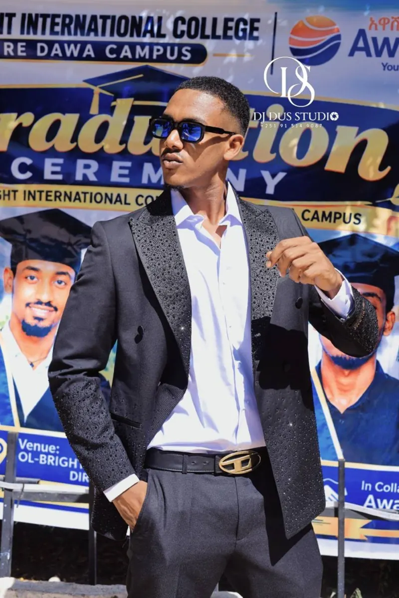 A guest poses beside the graduation banner